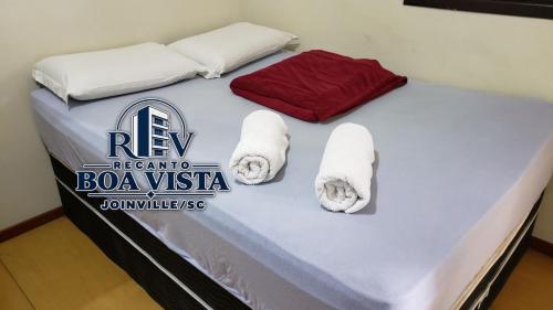 a bed with towels on top of it at Recanto Boa Vista in Joinville