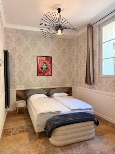 a bedroom with a bed and a chandelier at Le Clocher de la Duchesse in Bonnelles