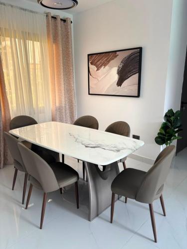 a white table and chairs in a room at Signature Suite in Bijilo