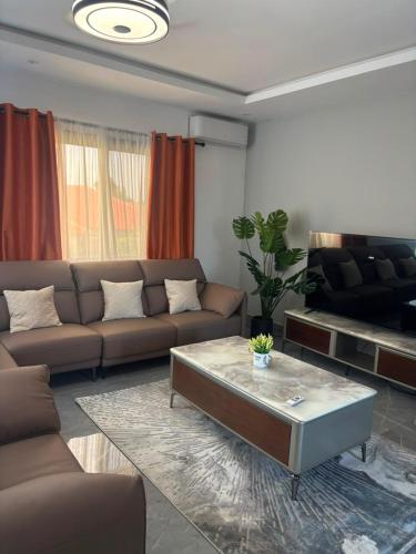 a living room with a couch and a coffee table at Signature Suite in Bijilo