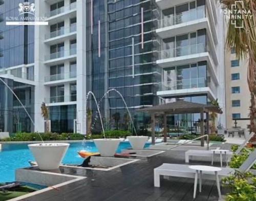 a pool in a building with tables and benches at Fontana infinity in Manama