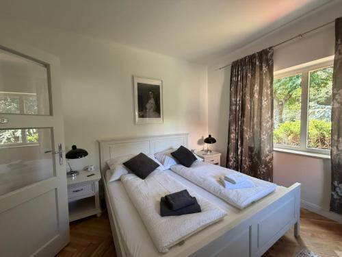 a bedroom with a white bed with two pillows at Stadthaus "Villa Moser" nahe Schloss Esterhazy in Eisenstadt