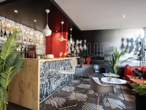 a restaurant with a bar with tables and chairs at ibis Cannes Plage La Bocca in Cannes