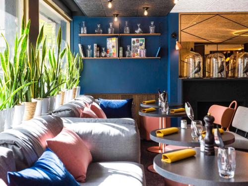 a room with couches and tables in a restaurant at Mercure Bordeaux Centre Ville in Bordeaux