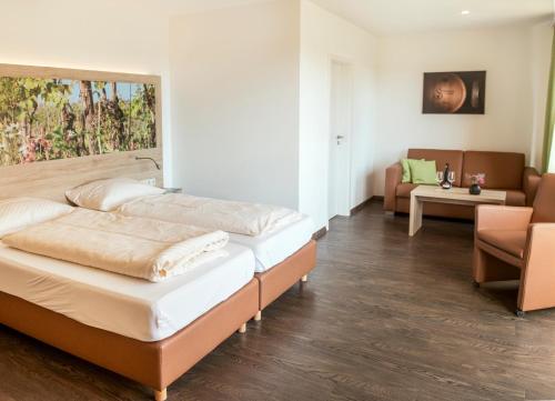 a bedroom with two beds and a living room at Pension Weingut Schwab in Thüngersheim