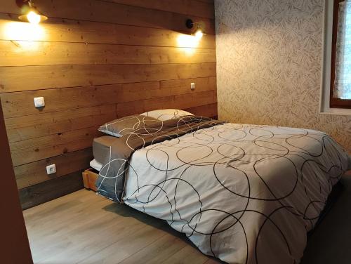 a bedroom with a bed in a room with wooden walls at La cascade de Grignon - Appartement - Pizzeria - Parking Vélos - Room Service in Grignon