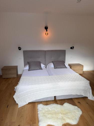 a bedroom with a large white bed with two pillows at Condhotel Fanti Ski & Bike in Valdisotto