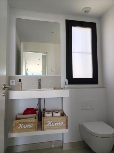 a bathroom with a sink and a toilet and a mirror at Higuerón 5821 in Málaga