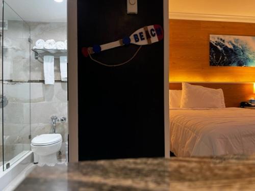 a room with a bedroom with a bed and a toilet at Ocean Manor Tiki Sunset Retreat in Fort Lauderdale