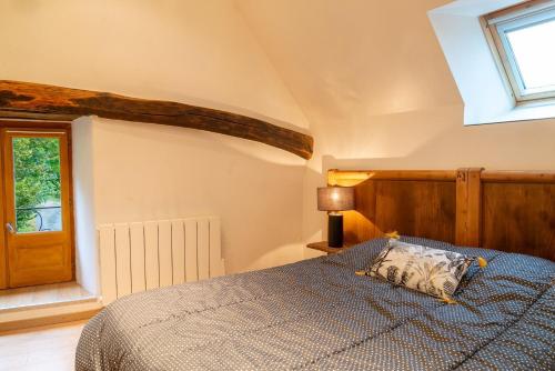 a bedroom with a bed and a window at La forge 2/5 personnes in Saint-Pierre-de-Nogaret