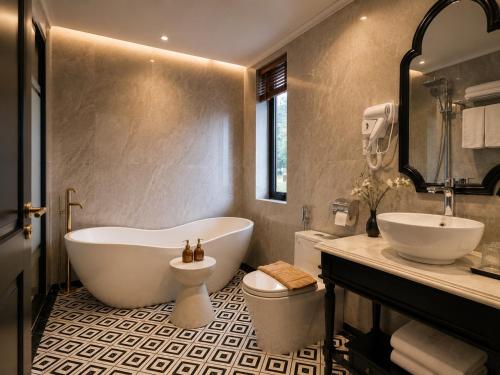 a bathroom with a tub and a toilet and a sink at Anara Sapa Hotel & Coffee in Sapa