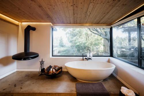 a bath tub in a bathroom with a large window at Rosemary Hill Farm in Pretoria