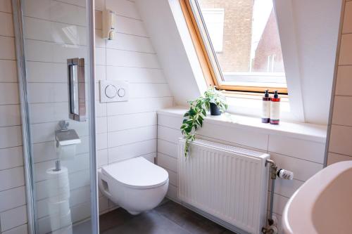 a bathroom with a toilet and a window at Short Stay Wageningen in Wageningen