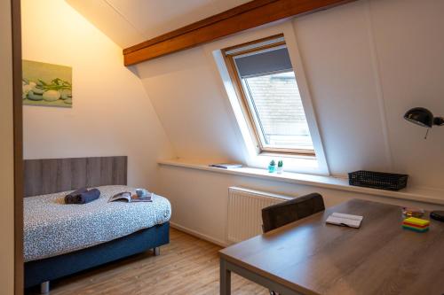 a bedroom with a bed and a table and a window at Short Stay Wageningen in Wageningen