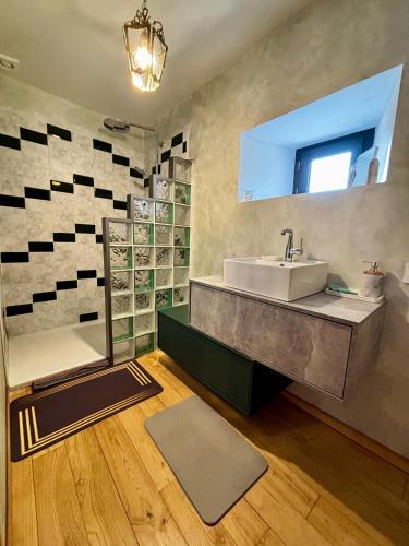 a bathroom with a sink and a bath tub at L’Angelina in Martrin