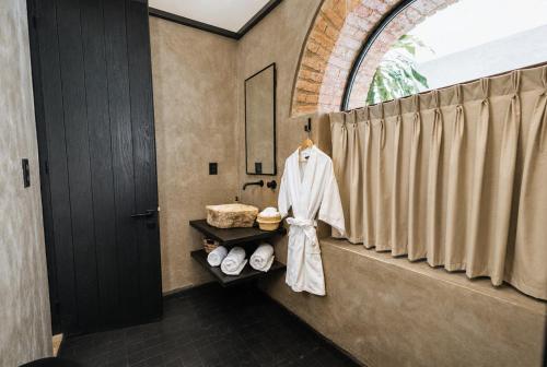 a bathroom with a robe hanging on a shower curtain at Casa Levonka in Oaxaca City