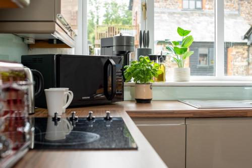 a kitchen counter with a microwave and a coffee maker at Trespaddick, coastal views Treworgie Barton in Bude