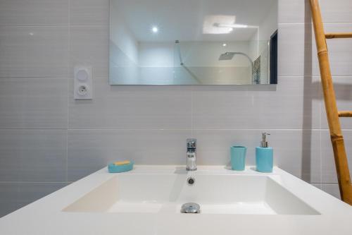 a white sink in a bathroom with a mirror at La maison de flavie in Sainte-Cécile-dʼAndorge