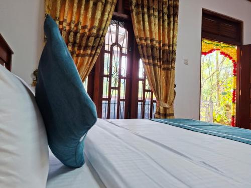 a bed with blue pillows in a room with a window at Nature's Rest in Ella
