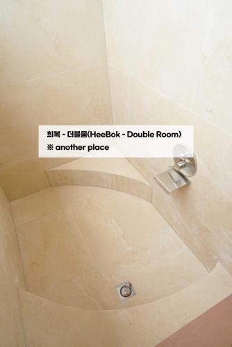 a sign for a shower in a bathroom at Dorandoran Guesthouse in Gyeongju