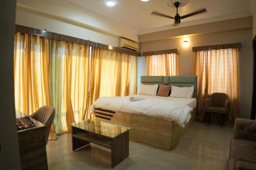 a bedroom with a bed and a living room at Hotel Alaska in Patna