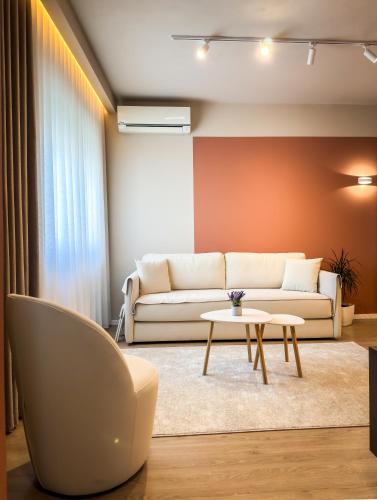 a living room with a couch and a table at All Seasons Apartments - Free Parking & City Center in Shkodër