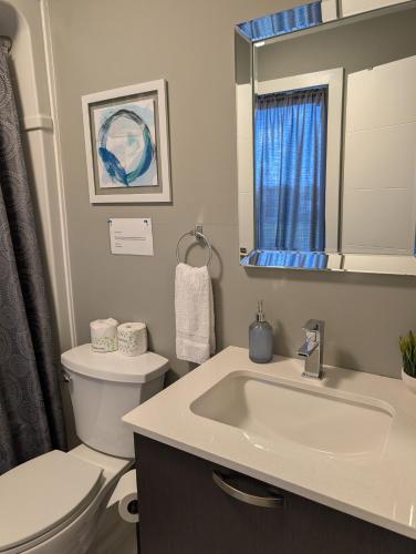 a bathroom with a sink and a toilet and a mirror at Clifton Hill suite 2201 in Niagara Falls