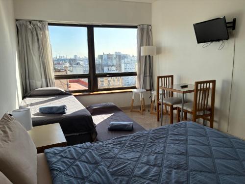 a hotel room with two beds and a large window at APART CyJ OBELISCO in Buenos Aires