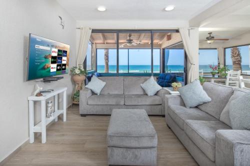 a living room with a couch and a tv at Super Beachfront Condo Ground Level on Sandy Beach in Puerto Peñasco