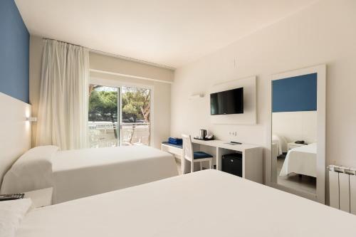a hotel room with two beds and a desk at Hotel Best Oasis Park in Salou