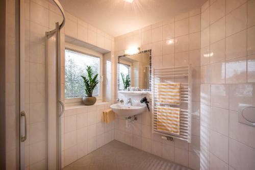 a bathroom with a sink and a mirror and a shower at edelweiss lounge restaurant hotel pizza cafe billard gasthof in Mayrhofen
