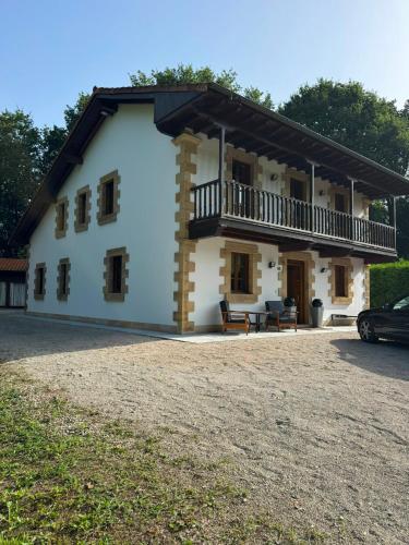 a large white house with a balcony on the side at Finca La Sierra in Abionzo
