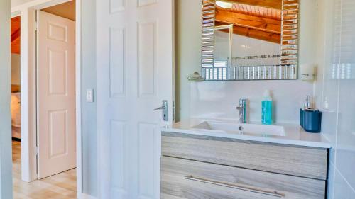a bathroom with a sink and a mirror at The Fisherman's LAB Cabin in Hermanus