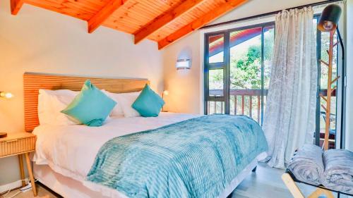 a bedroom with a bed and a large window at The Fisherman's LAB Cabin in Hermanus