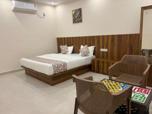 a bedroom with a bed and a table and chairs at Estoria Hotel and Resort in Mysore
