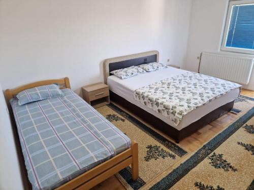 a bedroom with two twin beds and a rug at Apartman Vujovic in Zlatište