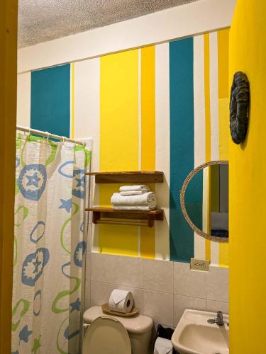 a bathroom with a toilet and a sink at Arbol de Fuego Eco-hotel in San Salvador