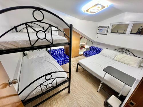 two bunk beds in a small room with a bedskirts at J&D Fully-Aircon 400mbps Parking WiFi 6pax in Canaman
