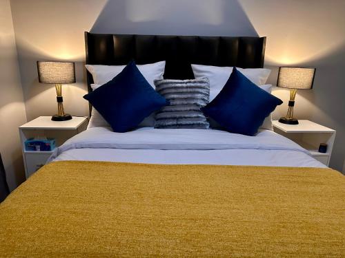a bedroom with a large bed with blue pillows at Nova Apartments- MbabaneCBD in Mbabane