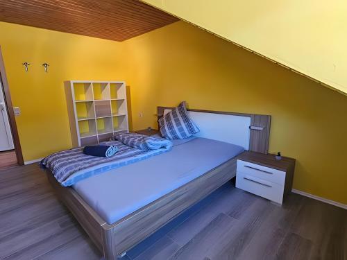 a bed in a room with a yellow wall at Ferienwohnung Riesling in Burg