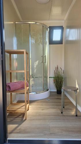 a bathroom with a shower with a bench and a chair at Camping Schlaffass Odin in Burg