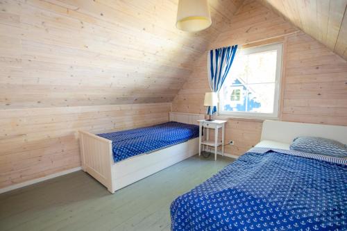a bedroom with two beds in a wooden cabin at Marynarskie Domki in Pobierowo