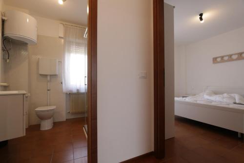 a bathroom with a bed and a toilet in a room at Reunia apartments in Ragogna