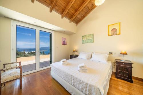 a bedroom with a bed with a view of the ocean at Villa Emelisse by Villa Plus in Fiskardo