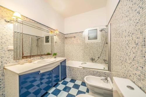 a bathroom with a sink and a tub and a toilet at Villa Emelisse by Villa Plus in Fiskardo
