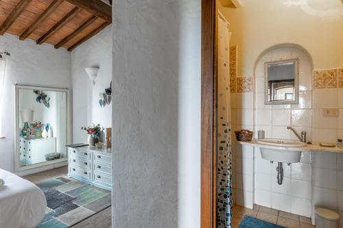 a white bathroom with a sink and a mirror at Agriturismo Quarantallina in Buonconvento