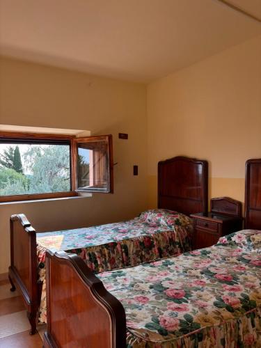a bedroom with two beds and a window at Podere Ortacavoli in Terriccio