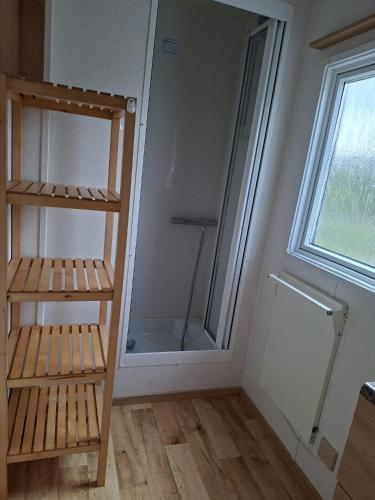 a bathroom with a walk in shower next to a window at De Zandparel in Poortvliet
