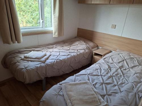 a bedroom with two beds and a window at De Zandparel in Poortvliet
