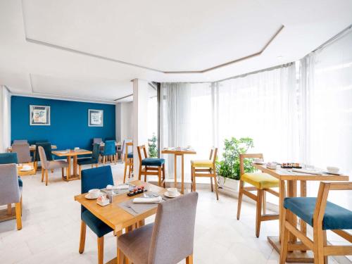 a dining room with wooden tables and chairs at Le Diwan Hotel Rabat - MGallery Collection in Rabat